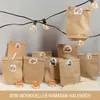 A collection of brown paper bags decorated with stickers, arranged on a surface with string lights and small candles. Produktbild-Vorschau