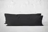 Two black body pillows are placed side-by-side on a light gray surface in front of a white brick wall. Produktbild-Vorschau