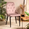 A pink velvet chair is placed in a room with plants and decorative items. Náhľad obrázku produktu