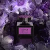A perfume bottle is displayed in front of a backdrop of purple amethyst crystals. Anteprima dell’immagine prodotto