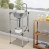 An outdoor sink setup with a pot and glasses of juice on a shelf. Náhled obrázku produktu