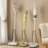 Three different vacuum cleaners are displayed standing upright on black stands against a light beige wall. Produktbild-Vorschau