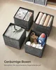 Four fabric storage boxes filled with various items, placed on a wooden floor. Produktbild-Vorschau