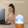 A woman is working on a computer while a mushroom-shaped humidifier is operating on the desk. Náhled obrázku produktu