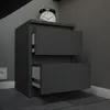 A modern, dark gray nightstand with two open drawers is shown from a slightly angled front view. Voir les images du produit