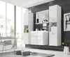 A modern, glossy white bathroom vanity set with tall cabinets and a mirror, set against a dark tiled wall and a large window overlooking a residential area. Náhled obrázku produktu
