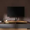 A TV stand with a TV on it, placed against a textured brown wall. Náhled obrázku produktu