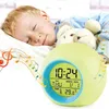 A young boy sleeping next to a digital alarm clock that is displaying the time and temperature. Produktbild-Vorschau