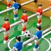 A close-up view of a foosball table with several player figures and the ball. Podgląd zdjęcia produktu