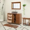 A bathroom vanity with a stone sink, storage baskets, and a mirror, along with a shower and a wooden bench. Podgląd zdjęcia produktu
