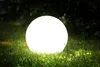 A glowing white sphere sits on a grassy lawn at dusk, with dark foliage in the background. Náhľad obrázku produktu