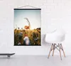 A poster with a floral image is hanging on a white brick wall, next to a white chair and a skateboard. Produktbild-Vorschau
