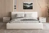 A bedroom scene featuring a bed, nightstands, and wall art. Produktbild-Vorschau