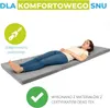 A woman is lying on a gray folding mattress on a white background. Produktbild-Vorschau