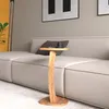 A wooden side table with a cup on it, placed next to a sofa in a living room. Náhled obrázku produktu