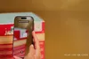 A hand is holding a smartphone, scanning a QR code on a product box. Anteprima dell’immagine prodotto