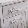 A close-up view of two drawers of a white wooden cabinet, each with the word "Home" in raised white lettering. Náhľad obrázku produktu