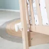 Close-up of a wooden baby crib with a star-patterned fabric lining. Produktbild-Vorschau