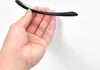 A hand holding a black cabinet handle against a white background. Produktbild-Vorschau