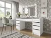 A modern bedroom or dressing room with a white vanity table and mirror with lights, a chair, and decorative wallpaper. Voir les images du produit