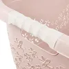 A close-up view of the handle of a pink laundry basket with a floral pattern. Produktbild-Vorschau