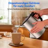 A person is pouring hot water from a silver electric kettle into a beige mug on a wooden table. Produktbild-Vorschau