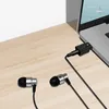 A laptop with a pair of earphones plugged into a USB-C to 3.5mm audio adapter. Produktbild-Vorschau