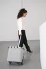 A woman is walking with a rolling shopping trolley. Produktbild-Vorschau