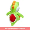 A large plush toy of the Nintendo character Yoshi, shown from the back with its belly open to reveal a red interior. A pink banner with text is at the bottom. Produktbild-Vorschau