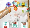 A baby lying in a crib with a mobile toy above them. The mobile has various colorful attachments including a bee, a flower, and a sun. There are also inset images showing how the mobile attaches to the crib. Náhled obrázku produktu