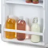 Three bottles of drinks are on a shelf inside a white refrigerator. Voir les images du produit