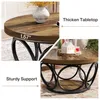 A round coffee table with a wood-grain top and a black metal base, shown with decorative items on top and a close-up of its features. Anteprima dell’immagine prodotto