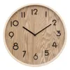 A round wall clock with a wood-grain face and black numbers and hands, set against a white background. Náhled obrázku produktu