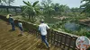 People are observing animals in a zoo enclosure from a wooden walkway. Produktbild-Vorschau