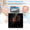 A thermostat is displayed in front of two smiling elderly people, with a television in the background. Náhled obrázku produktu