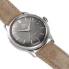 A close-up shot of a watch with a gray dial and a brown strap. Voir les images du produit