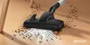 A vacuum cleaner head is shown cleaning debris from a wooden floor. The image highlights the suction power with visual effects. Produktbild-Vorschau
