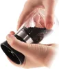 Hands holding a pepper grinder filled with peppercorns. Produktbild-Vorschau