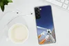 A smartphone with a soccer-themed case is placed on a desk next to a cup of coffee and earphones. Produktbild-Vorschau