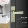 A door handle on a dark door, with a blurred interior visible through an open doorway. Produktbild-Vorschau