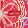 A close-up of a fabric with a colorful floral pattern and a red brand label. Náhľad obrázku produktu