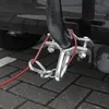 A close-up view of a red safety cable with a carabiner and ring attached to a trailer hitch. Produktbild-Vorschau