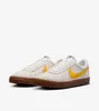 A pair of Nike Killshot 2 sneakers with yellow swooshes and brown soles, displayed on a white background. Podgląd zdjęcia produktu