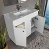 A white vanity with an open cabinet showing folded towels, next to a potted plant and a rug, with a window showing the ocean in the background. Náhled obrázku produktu