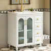 A white bathroom vanity with a ceramic sink and gold accents, set against a tiled wall. Produktbild-Vorschau
