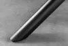 A close-up shot of the black metal leg of a table resting on a gray textured surface. Produktbild-Vorschau