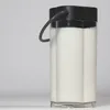 A close-up shot of a milk container with a black lid and handle, filled with white liquid. Anteprima dell’immagine prodotto