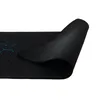 A close-up view of a black gaming mousepad with a hexagonal pattern and blue accents, partially rolled up to show the textured underside. Voir les images du produit