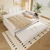 A white daybed with a pull-out trundle bed is set up in a brightly lit room with a window and blinds. Podgląd zdjęcia produktu