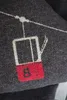 A close-up embroidered image of a ski gondola on a dark gray fabric. Produktbild-Vorschau